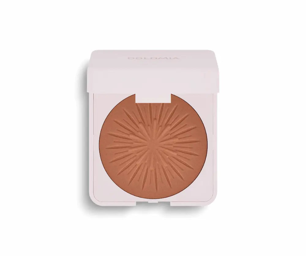Geöffnetes Bräunungspuder von Dolomia in heller rosa Dose mit braunem Puder und sonnenförmigem Relief, Vorderansicht.