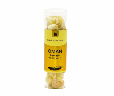 Transparentes Röhrchen mit cremefarbenen Weihrauch-Stücken und gelb-goldenem Etikett mit Aufschrift „OMAN Premium Weihrauch", Vorderansicht